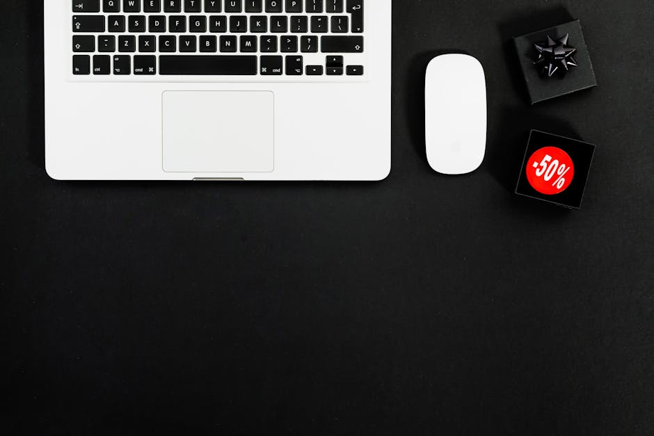 A group of diverse professionals collaborating in a modern office setting with laptops and technology.