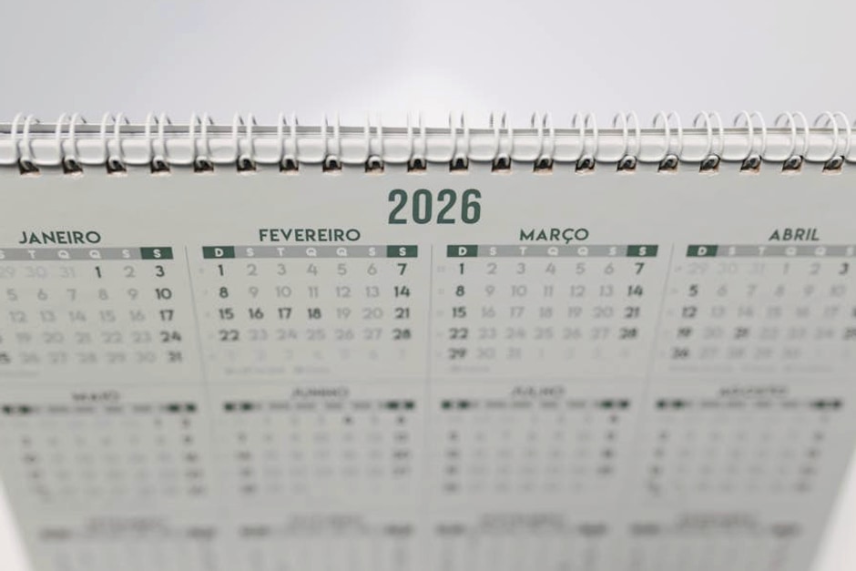 Close-up of a 2026 spiral-bound desk calendar with months in Portuguese.
