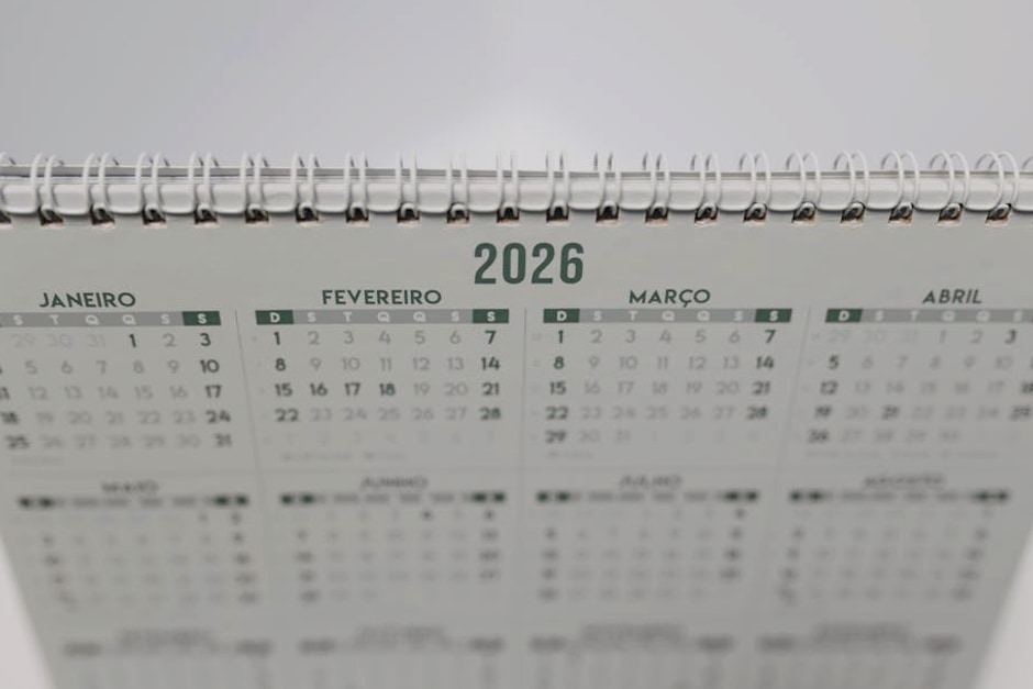 Close-up of a 2026 spiral-bound desk calendar with months in Portuguese.