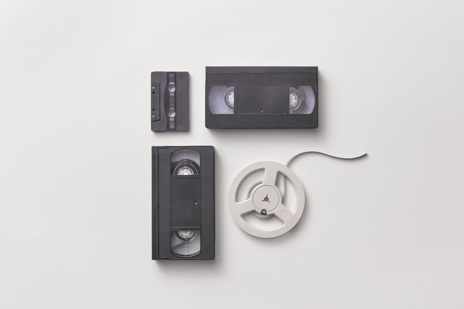 Collection of vintage audio and video tapes including VHS and cassette on a white background.