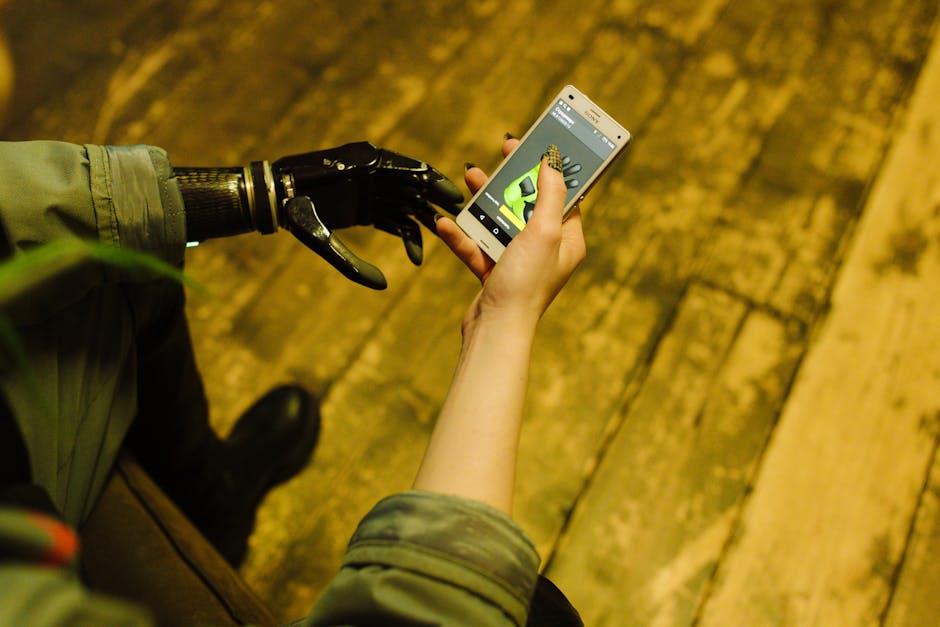 Person with prosthetic hand operating a smartphone, showcasing modern technology innovation.