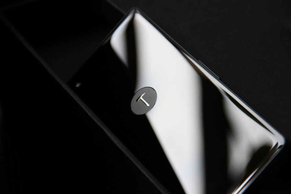 Elegant smartphone with chrome finish reflecting light, showcasing modern design.