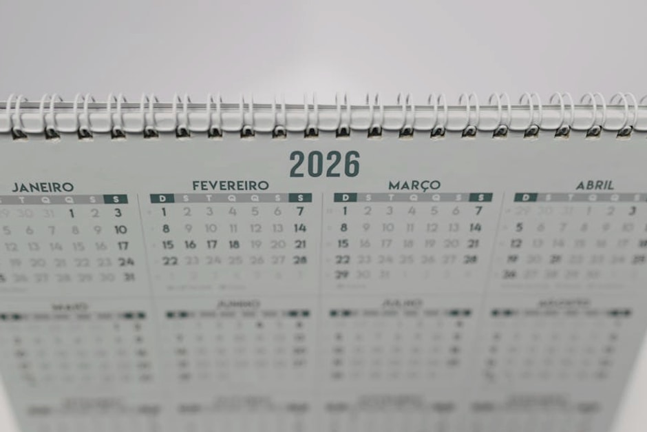 Close-up of a 2026 spiral-bound desk calendar with months in Portuguese.