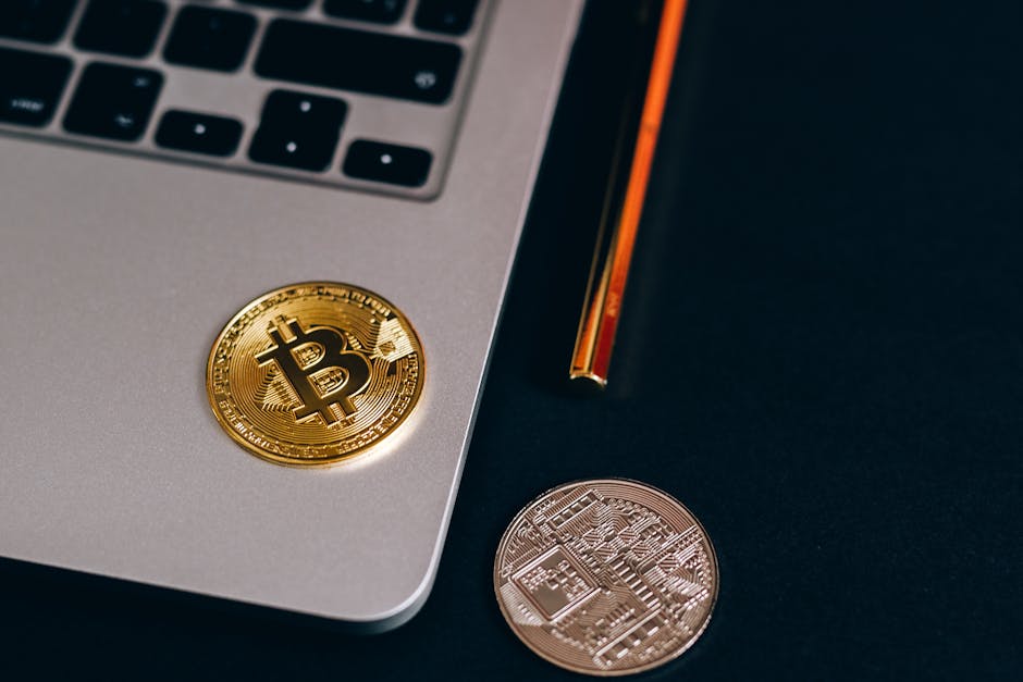 Close-up of Bitcoin and cryptocurrency coins on a laptop, symbolizing digital finance.