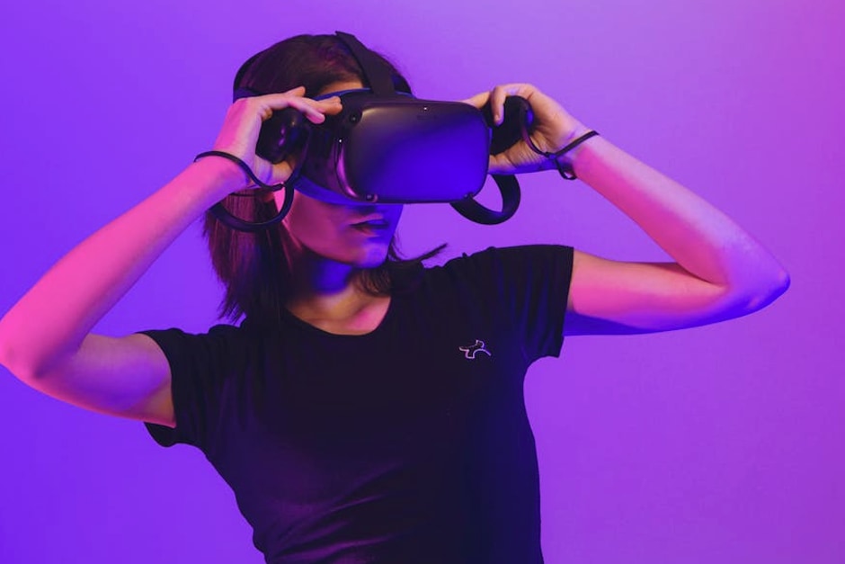 Woman wearing virtual reality headset immersed in a vibrant neon-lit gaming experience.