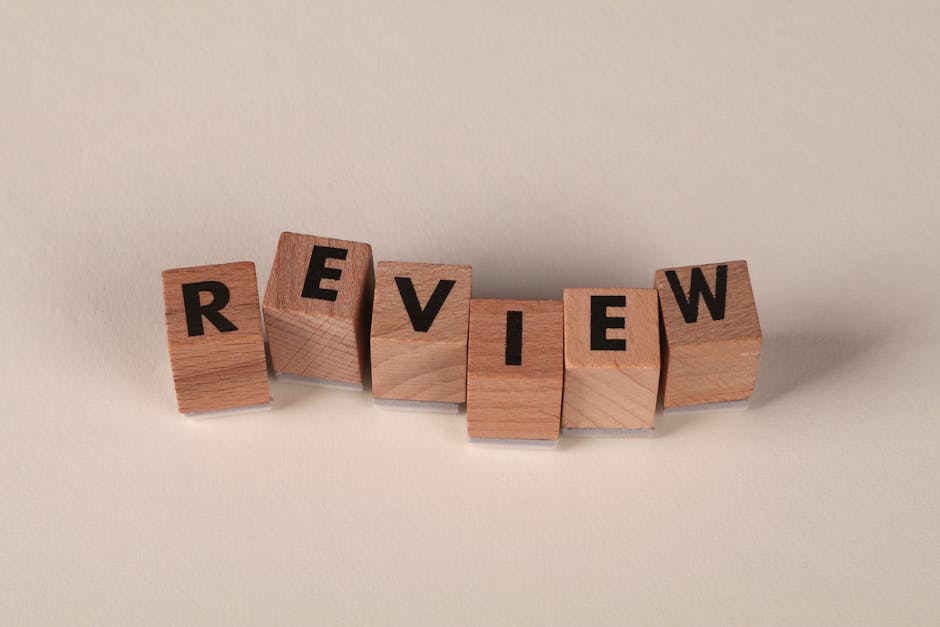 Wooden blocks with letters forming the word 'Review' on a soft pastel background.
