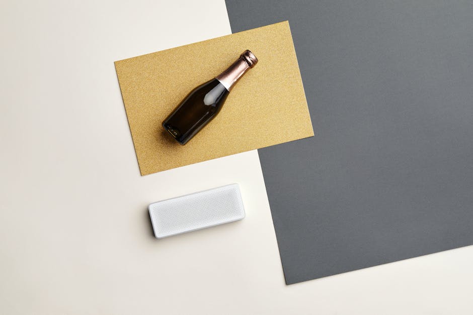 Minimalist composition featuring a champagne bottle and Bluetooth speaker on colorful backgrounds.