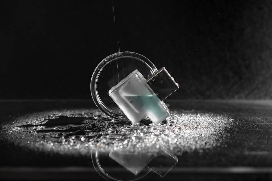 Minimalist close-up shot of a USB drive with water droplets on glass and dark background.