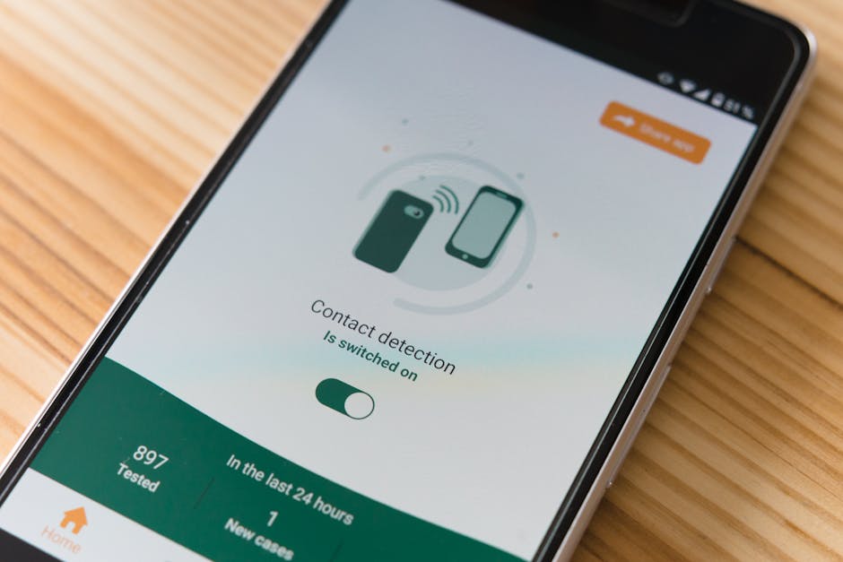 Close-up of smartphone displaying contact detection app on wooden surface.