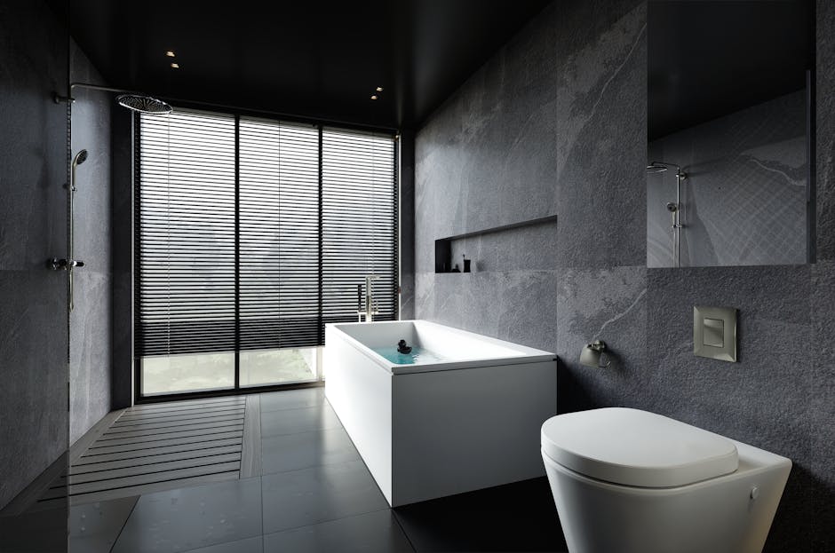 Sleek modern bathroom with a bathtub and dark stone tiles, offering a relaxing atmosphere.