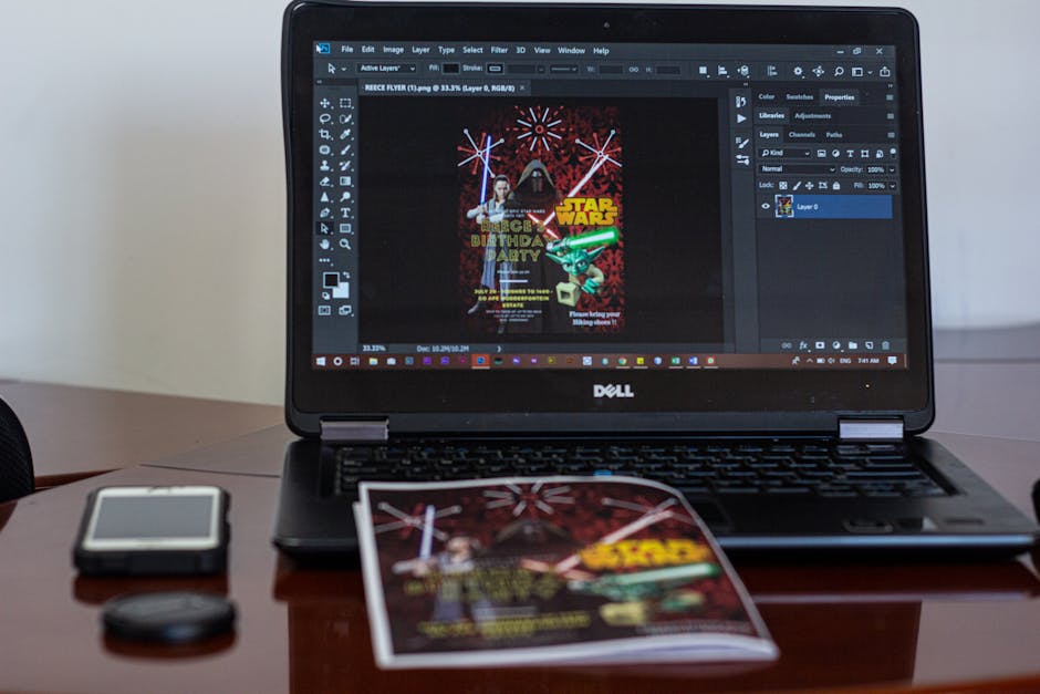 A laptop displaying Star Wars party invitation design in a workspace setting.