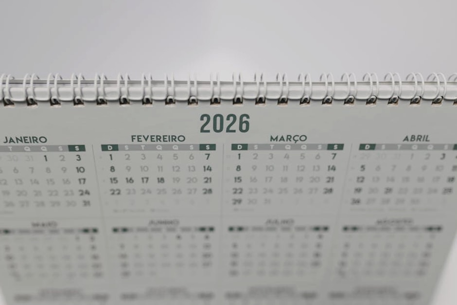 Close-up of a 2026 spiral-bound desk calendar with months in Portuguese.