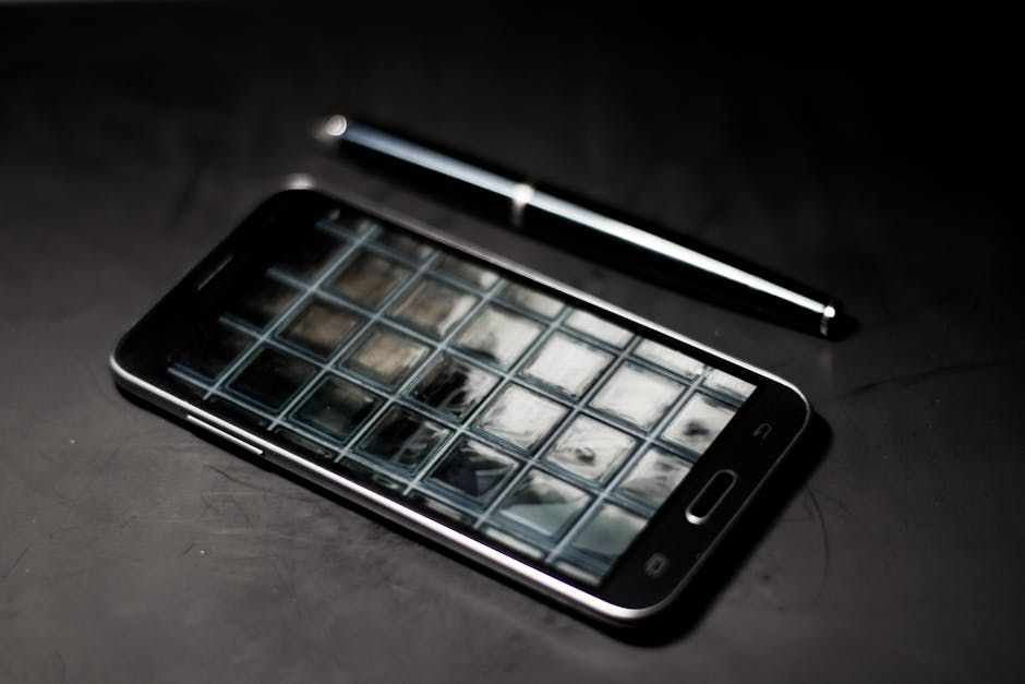 A sleek smartphone and pen on a modern desk, reflecting geometric patterns.
