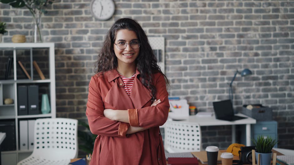 Young businesswoman with glasses smiling confidently in a stylish modern office