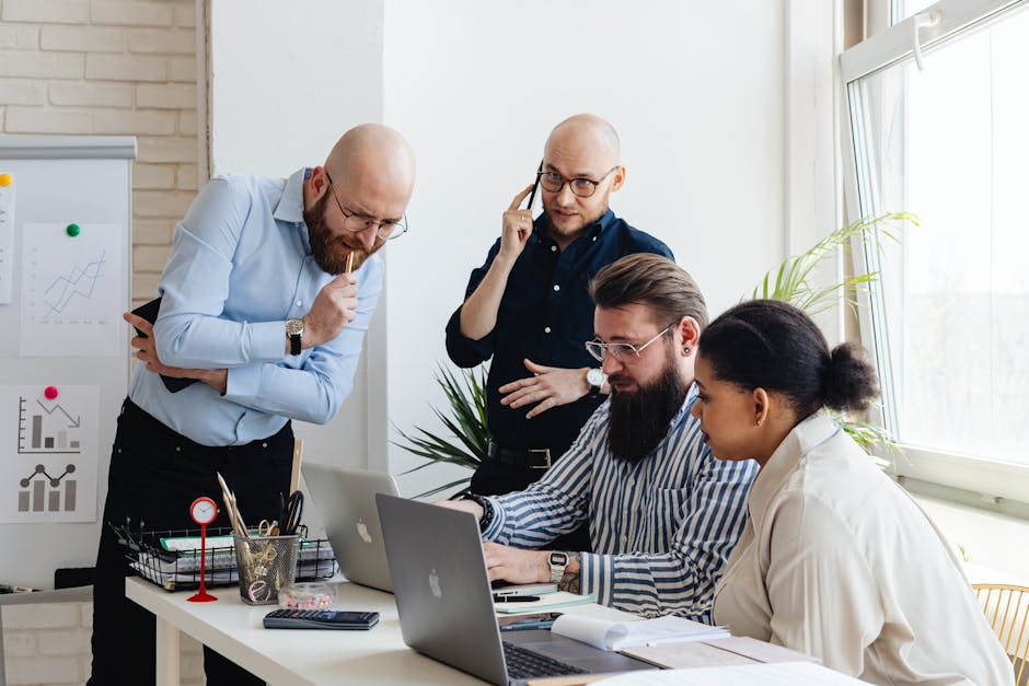 Multi-ethnic team collaborates on a project in a modern office setting, enhancing teamwork.