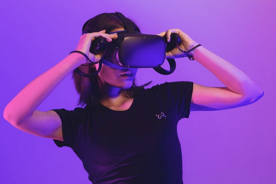 Woman wearing virtual reality headset immersed in a vibrant neon-lit gaming experience.