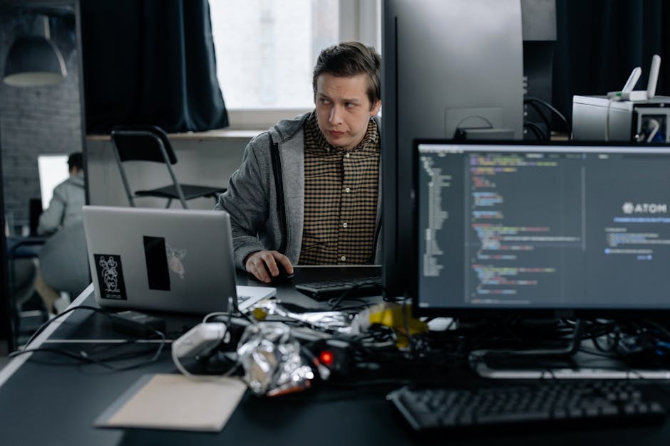 A programmer in a modern office working on computer code, showcasing a focused work environment.