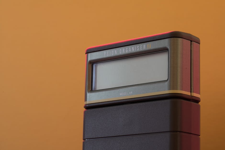 Psion Organizer II Model XP with vibrant orange backdrop showcasing vintage technology.