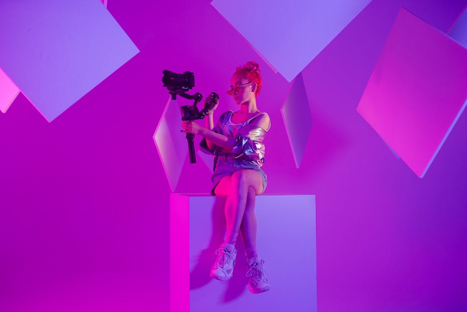 A young woman holding a gimbal in a neon-lit studio setting.
